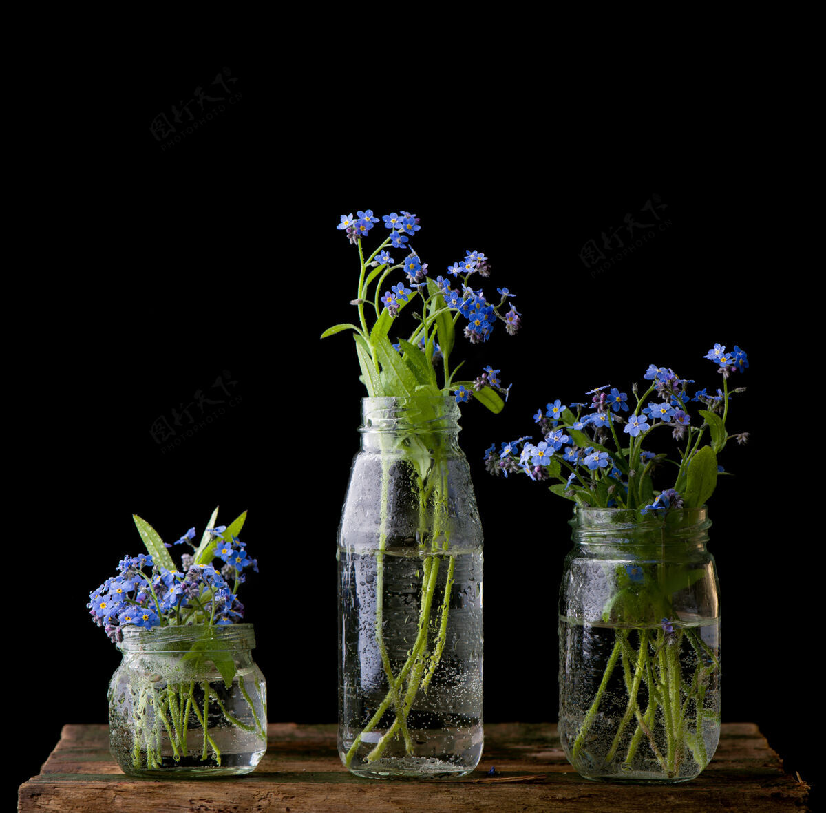 花瓣木桌上玻璃瓶里的花束植物乡村蓝色