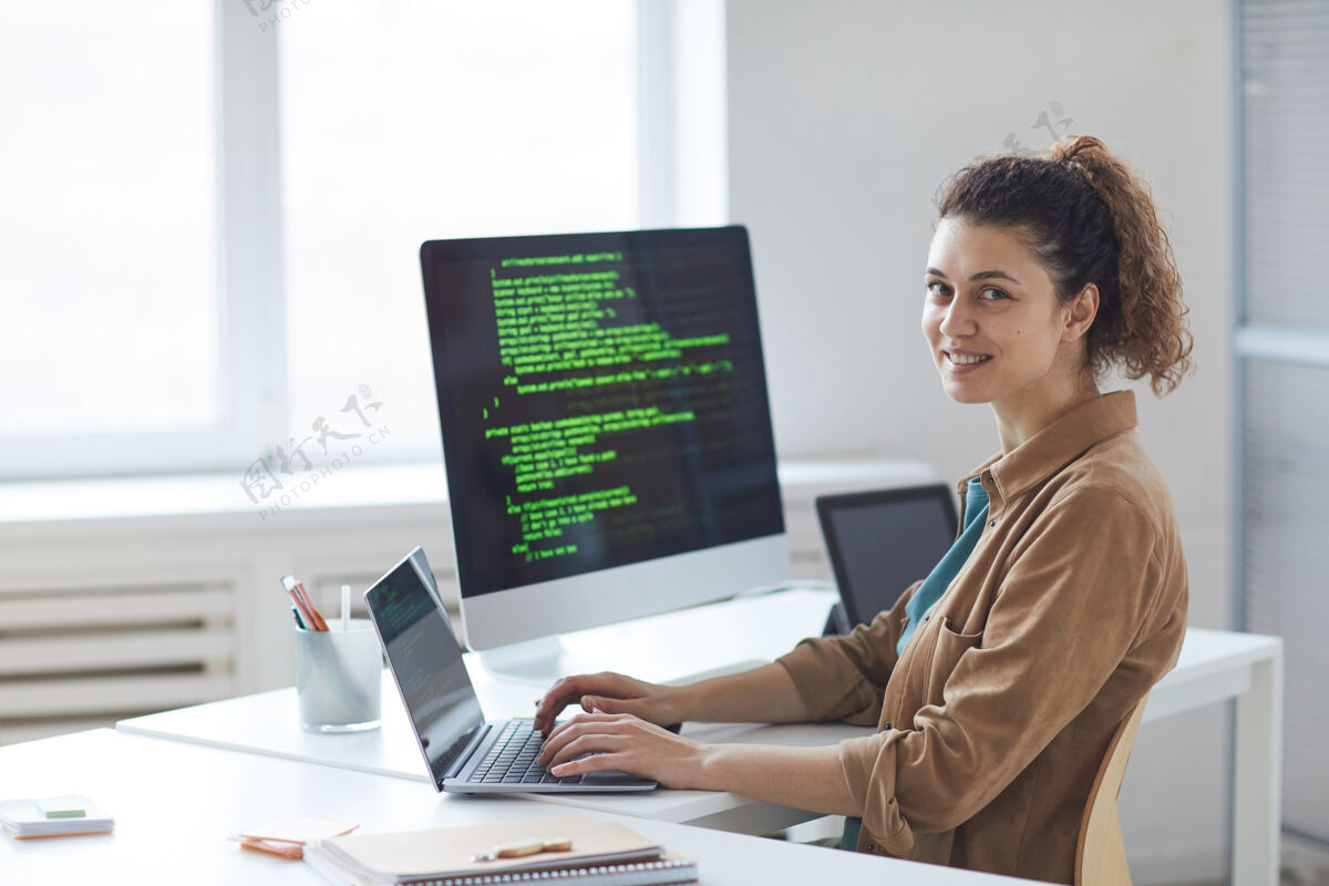 计算机显示器在办公室工作的年轻开发人员在电脑前微笑的画像成年人公司业务使用计算机