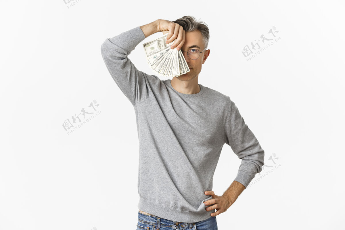 男性成功和富有的中年男子在灰色毛衣肖像 显示金钱室内快乐人