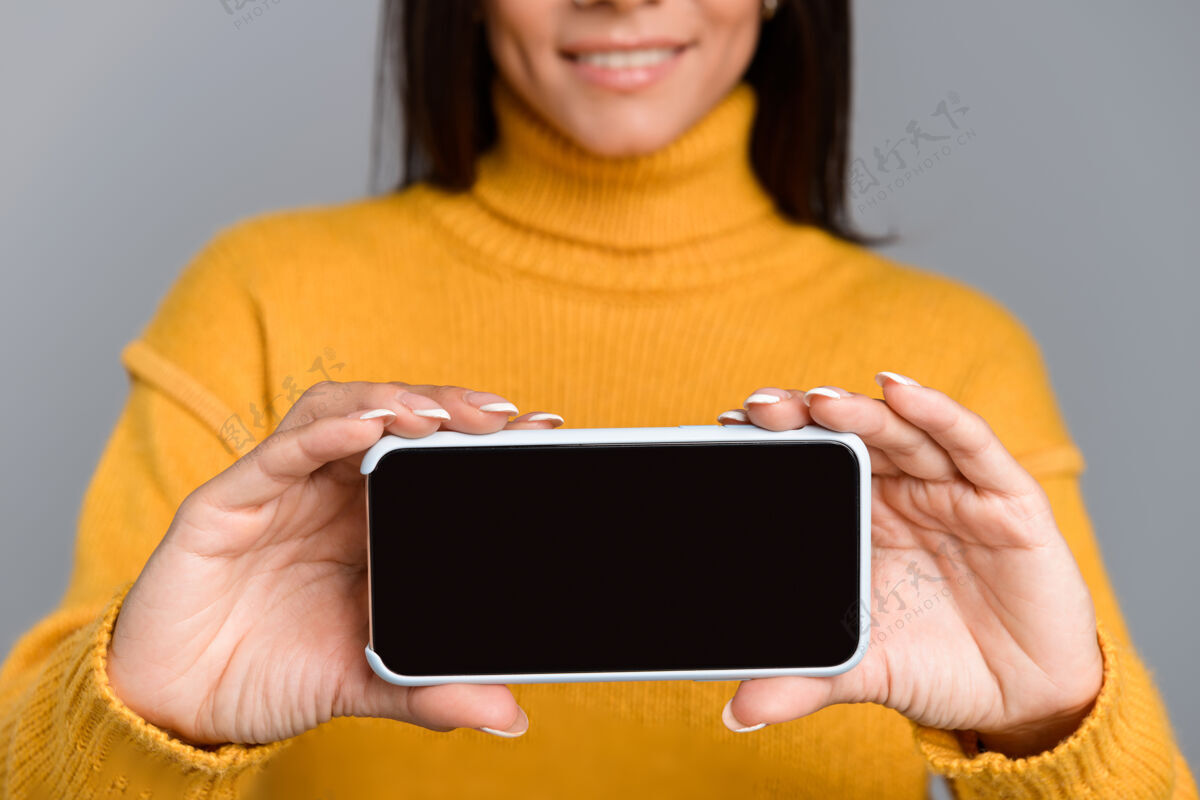 手臂剪下的图片惊人的兴奋的女人摆出孤立的灰色墙壁显示手机显示手休闲显示