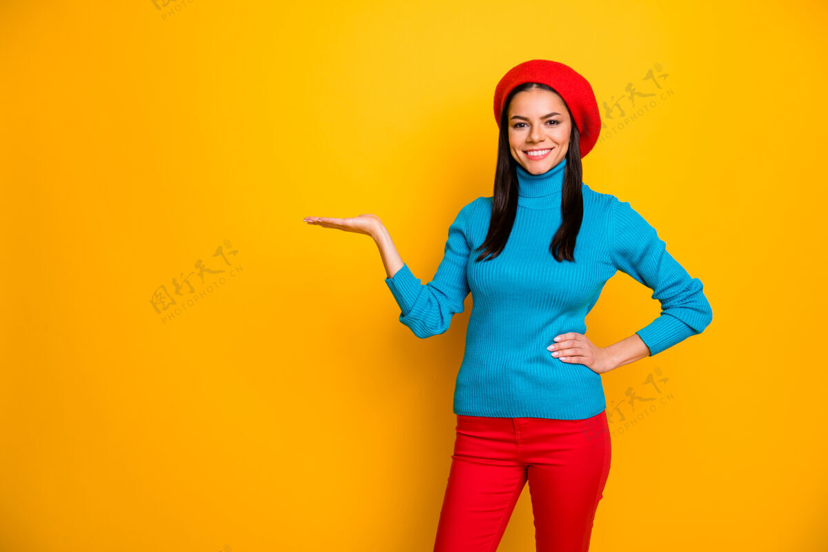 贝雷帽她的肖像她漂亮迷人可爱自信开朗活泼的女孩拿在手掌上复制空间广告很好的解决方案隔离在明亮生动的亮光充满活力的黄色墙壁手持套头衫推荐