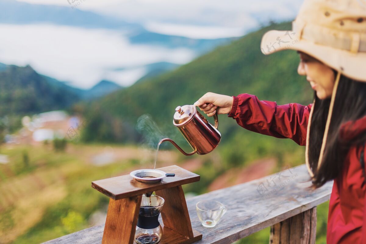 女人女咖啡师的手把热水从罐子里倒到山顶过滤器里的阿拉比卡咖啡过滤器浸泡咖啡