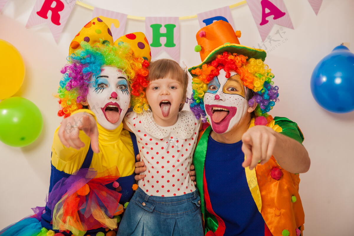 小丑假发快乐的情感小丑在一个节日与一个女孩显示他们的舌头生日礼物乐趣