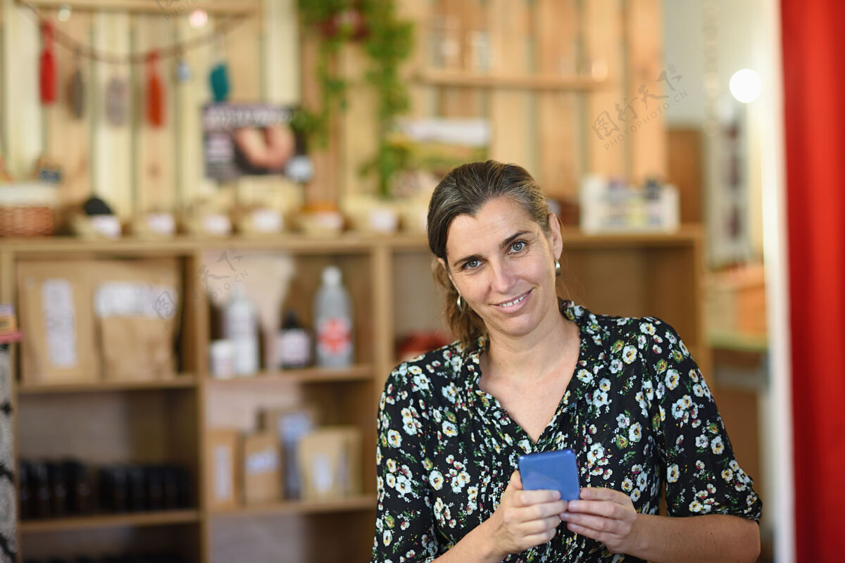 商店一个有进取心的女人拿着手机在商店里的画像企业家电话肖像