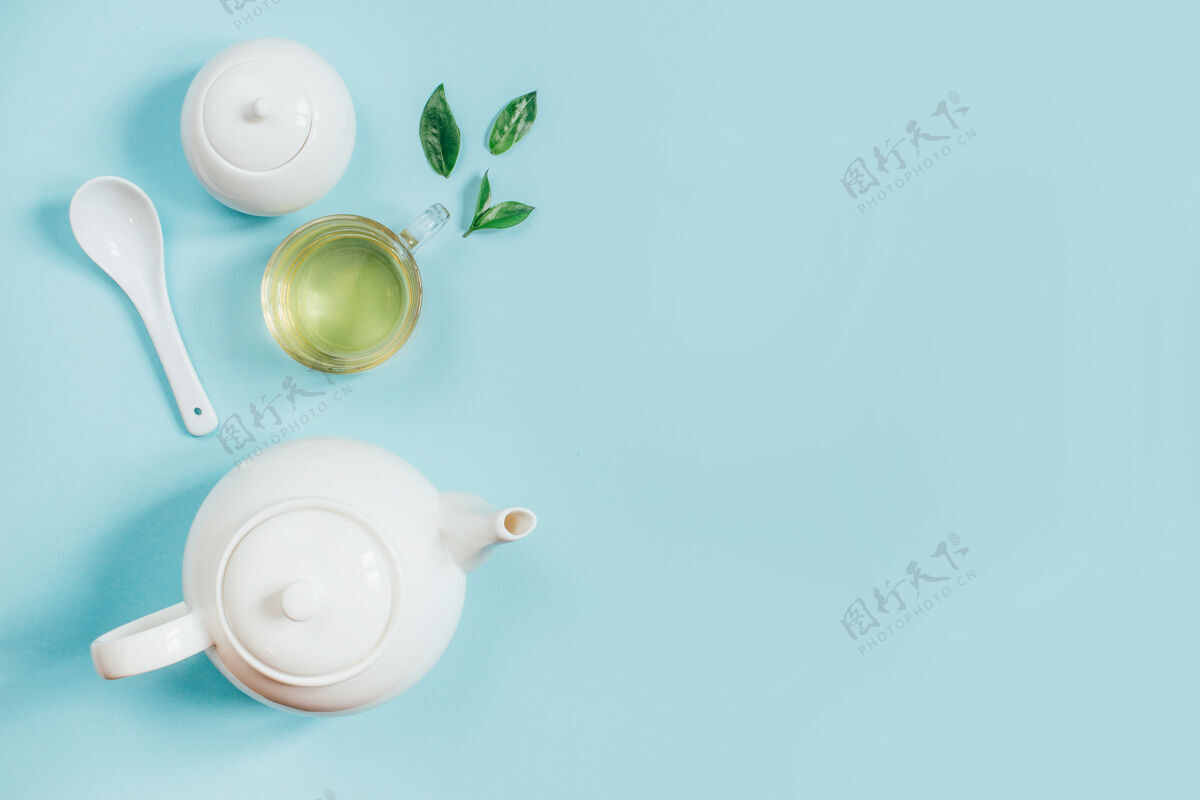白色茶壶一套茶具的俯视图茶壶糖碗杯上有茶水蓝色的表面特写茶茶道
