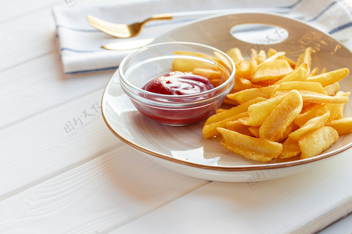 番茄酱放在木桌上的带酱汁的炸薯条土豆盘特写烹饪卡路里快餐