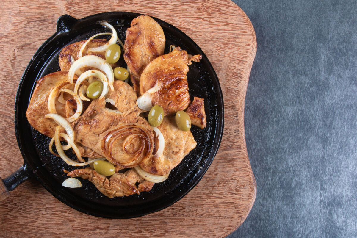 肉类铁板上的洋葱和橄榄烤鸡俯视图准备餐厅家禽