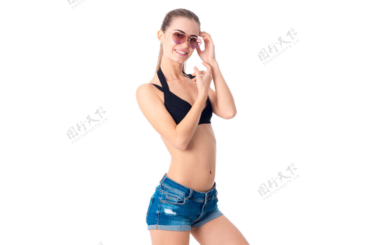 热穿着黑色泳装和性感牛仔裤的美女隔离在白墙上模特人泳装