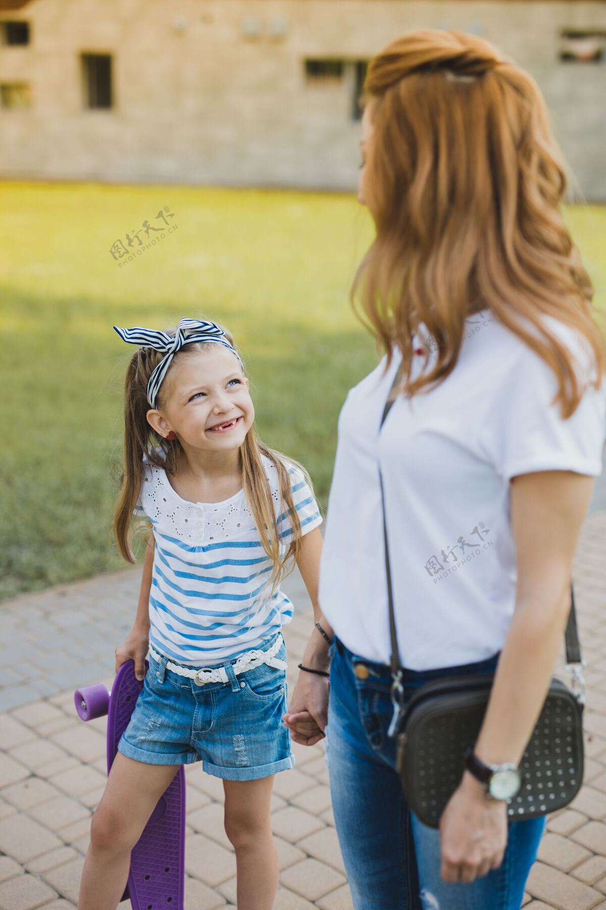 情绪紫罗兰色滑板体贴时尚的妈妈带着她带着紫罗兰色滑板的女孩去公园时感觉很放松移动运动公园
