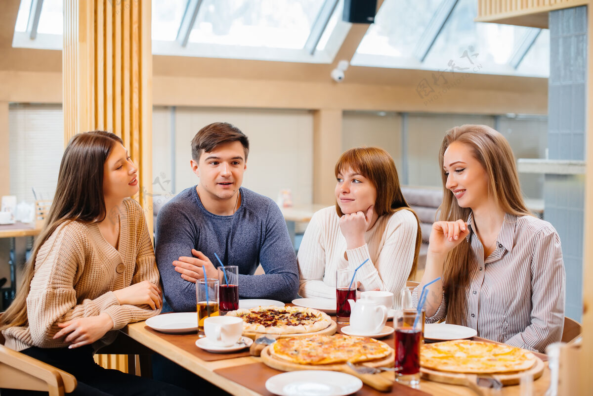 自拍一群年轻开朗的朋友正坐在咖啡馆里聊天 吃着披萨午餐在披萨店可乐肖像玩得开心
