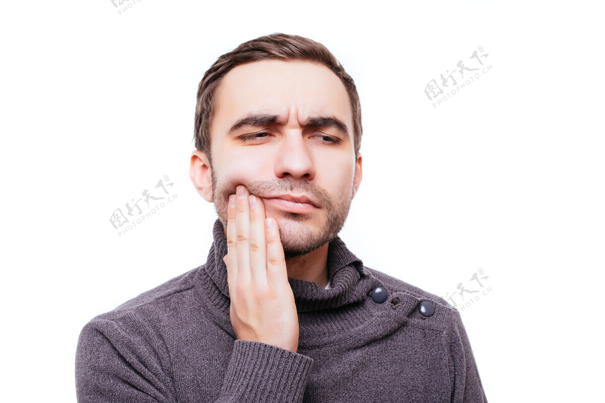 英国人有牙痛牙冠问题的年轻人的特写肖像 因为用手触摸嘴外的疼痛而要哭 隔离在白墙上雇员填充男孩