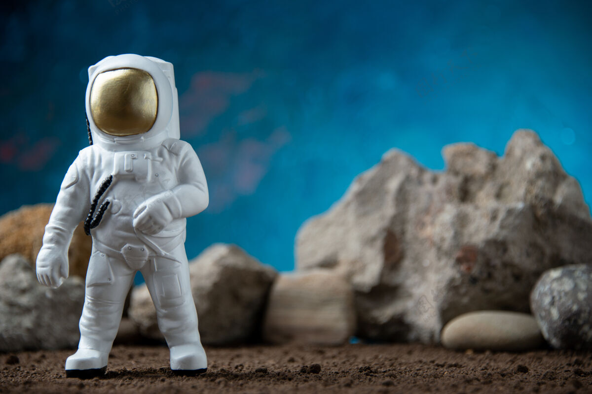 男性白色宇航员与月球上的岩石蓝色表面幻想宇宙科幻Fi宇宙男人