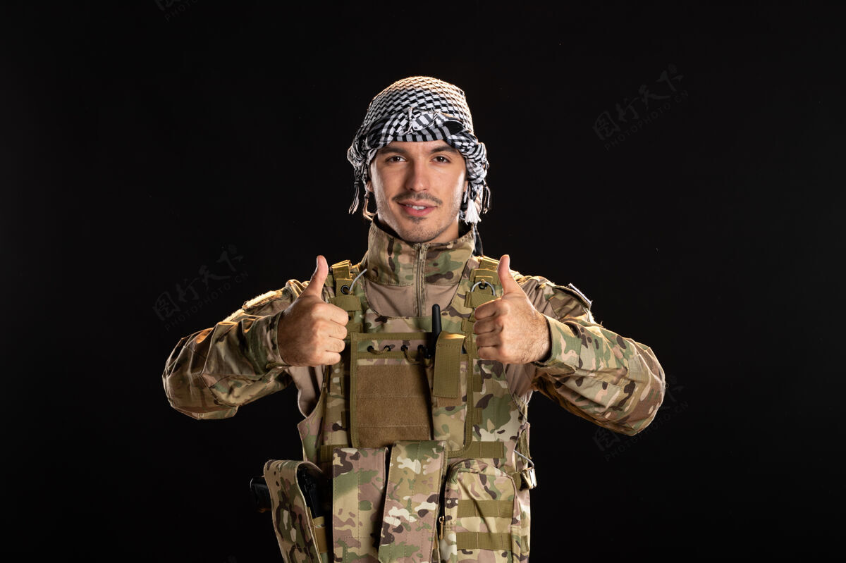 黑人身着军装的巴勒斯坦军人在黑墙上微笑服装人微笑
