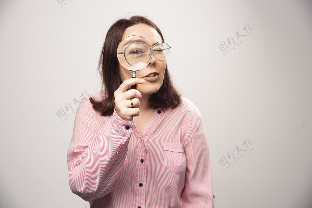 姿势手持放大镜的白色女士肖像高质量照片成人女士人类