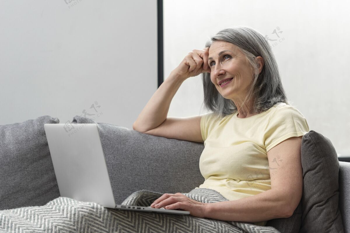 学习家里的老太太在沙发上用笔记本电脑书房笔记本电脑家庭