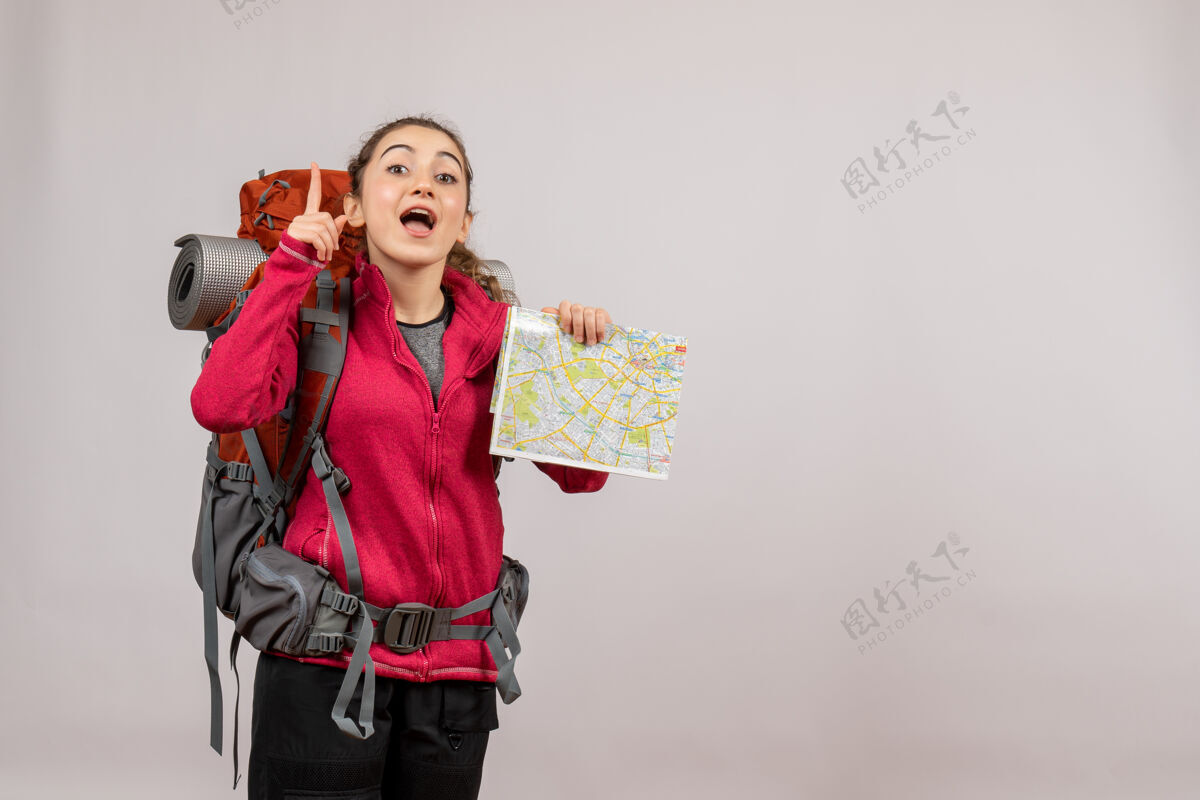 年轻的旅行者正面图年轻的旅行者拿着一个大背包 地图朝上女士旅行者旅游