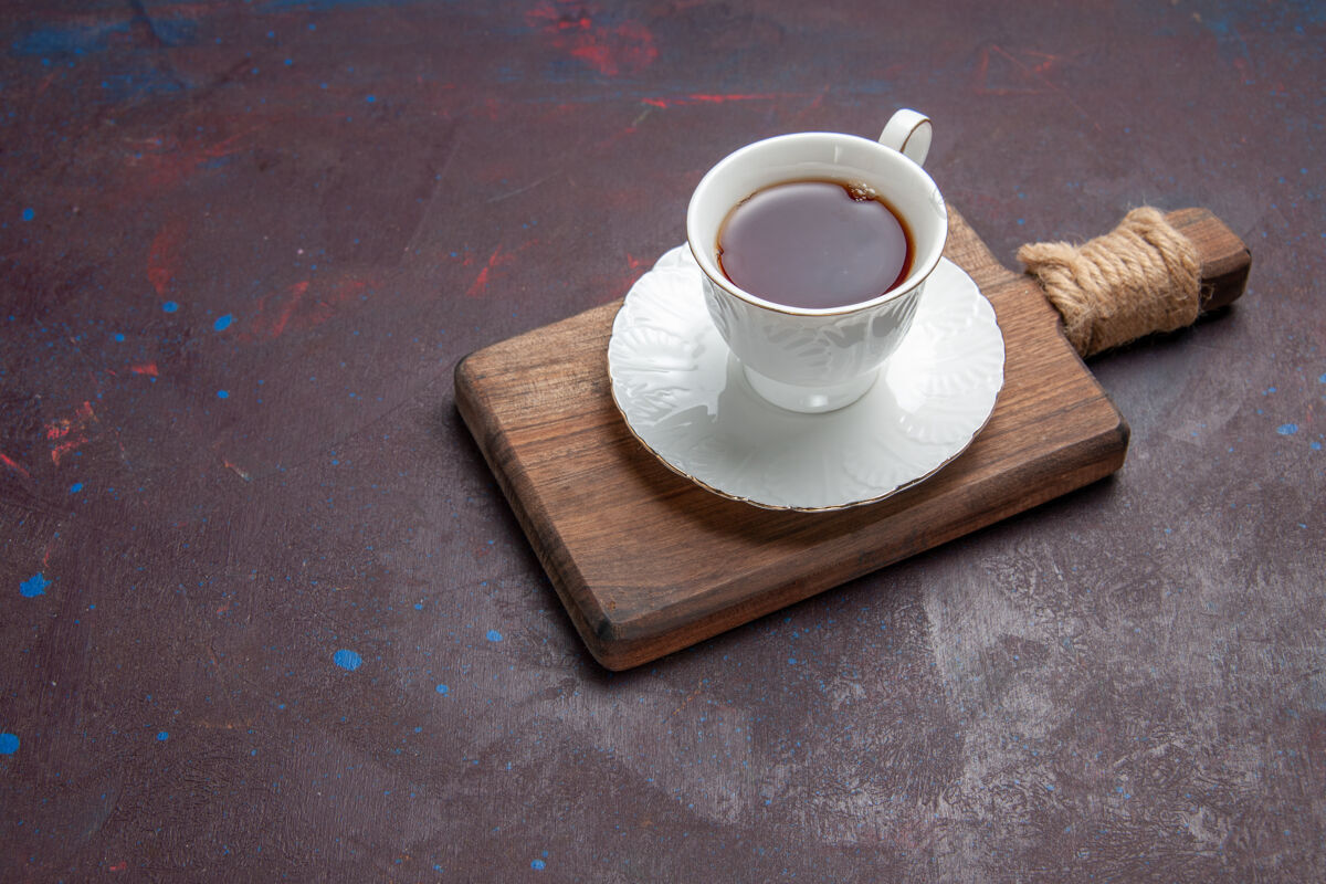 热的前视图茶杯内的玻璃杯与板上的黑暗空间仪式杯子茶杯