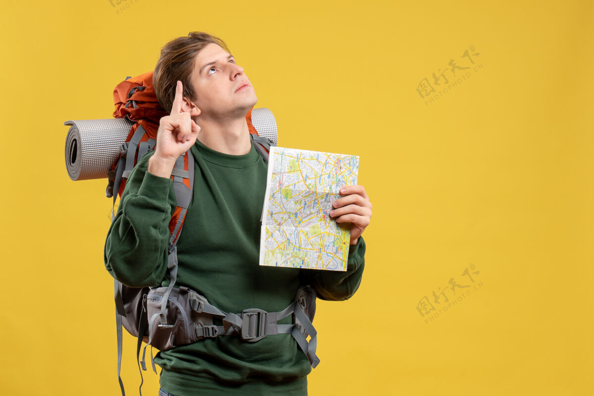 背包正面图年轻男子背着背包拿着地图黄色持有家伙