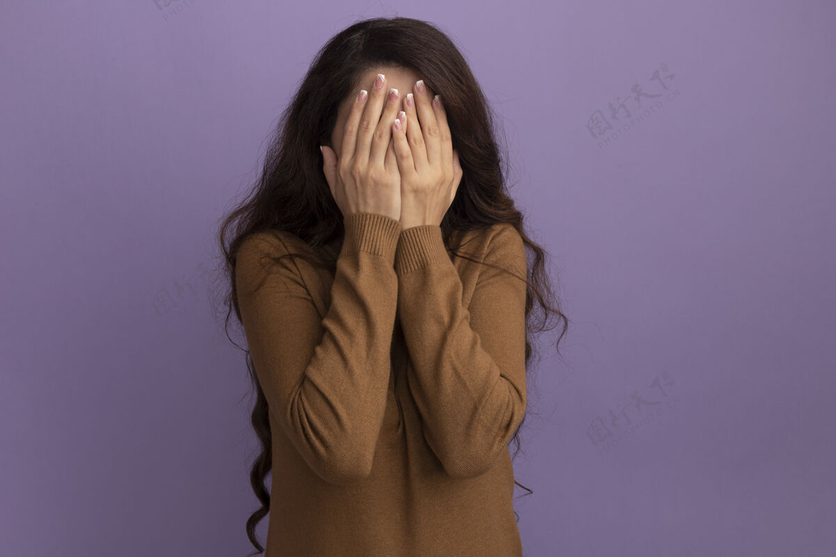 女孩年轻漂亮的女孩穿着棕色高领毛衣 脸上蒙着紫色的隔离墙姿势人毛衣