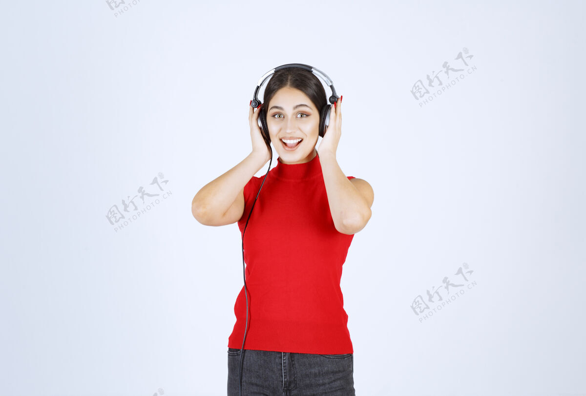 工作人员穿着红衬衫的Dj女孩戴着耳机 听着好听的音乐表演女性年轻人