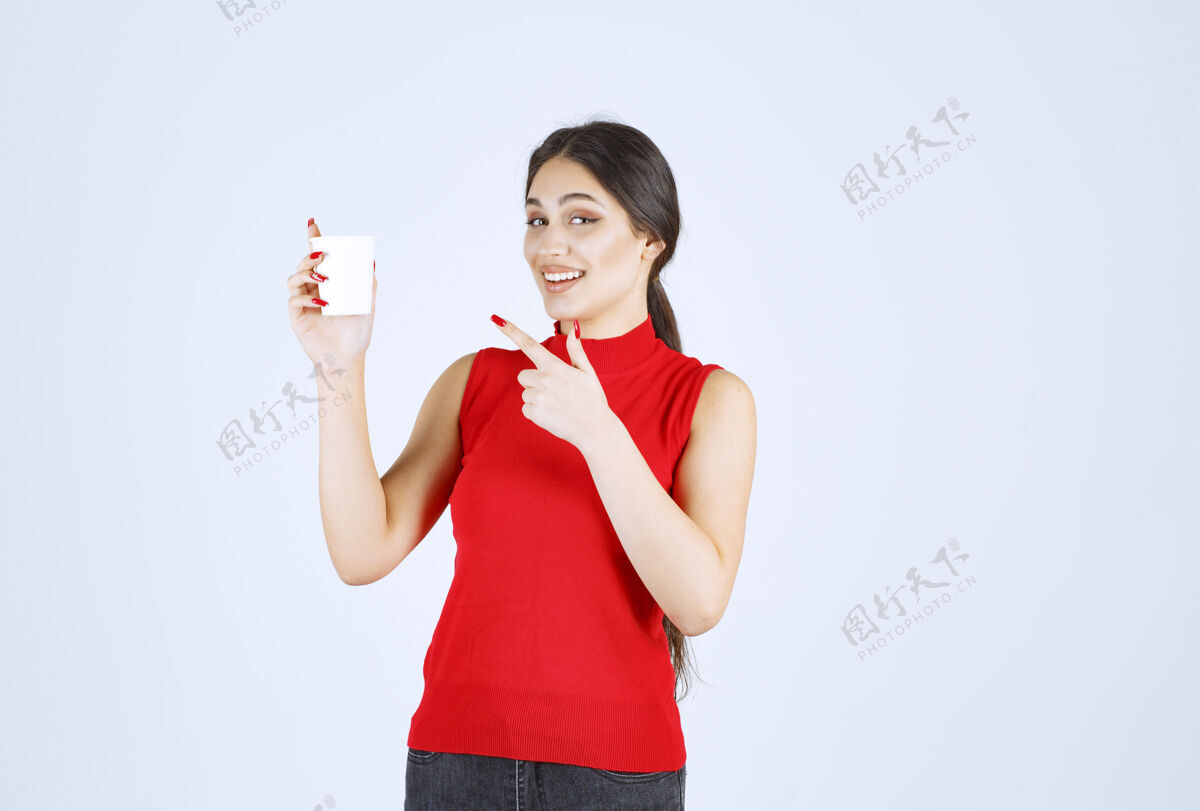 工人拿着一个白色咖啡杯指着它的女孩人职员女性