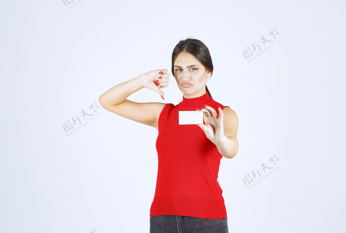 休闲一个穿着红衫的女孩拿着一张名片 看上去很困惑 很不满意服装失望成年人