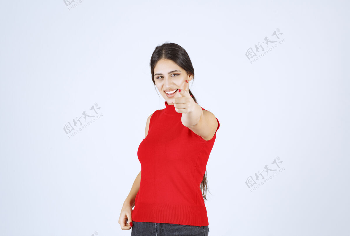 姿势穿红衬衫的女孩注意到前面有人在招呼他成年人指点模特