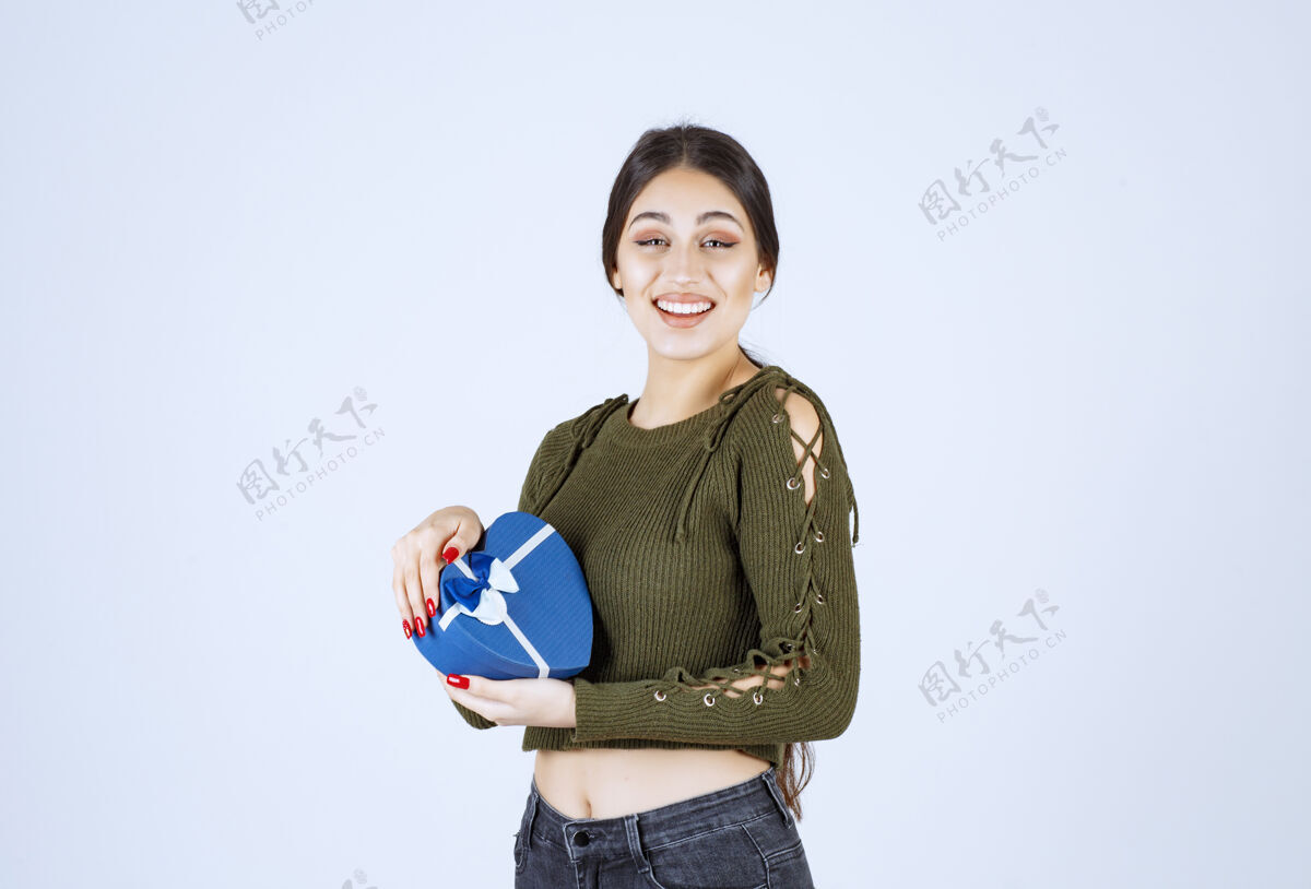 持有年轻女子拿着蓝色礼盒 表情愉快惊喜女孩女人
