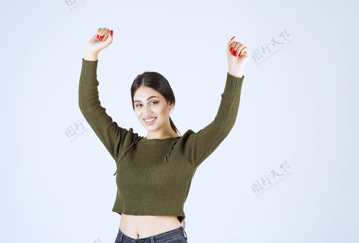 女孩一个年轻快乐的女模特站着举手的照片站立女人模特