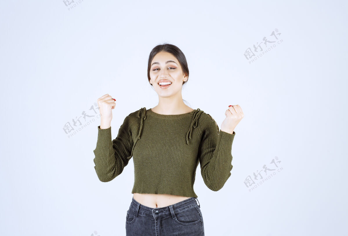 肖像一个年轻快乐的女模特站着举手的照片举起人模特