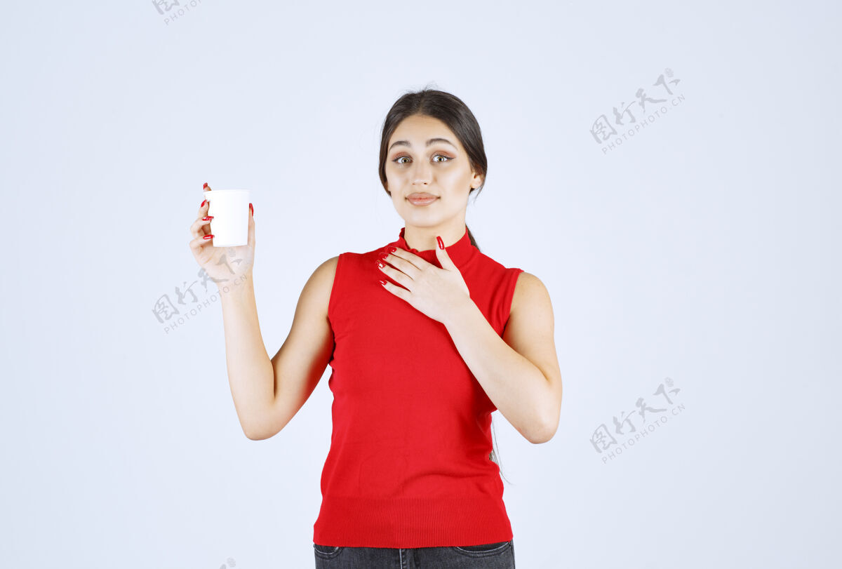 休闲穿着红衬衫的女孩拿着一个白色的咖啡杯指着自己职员工人人类