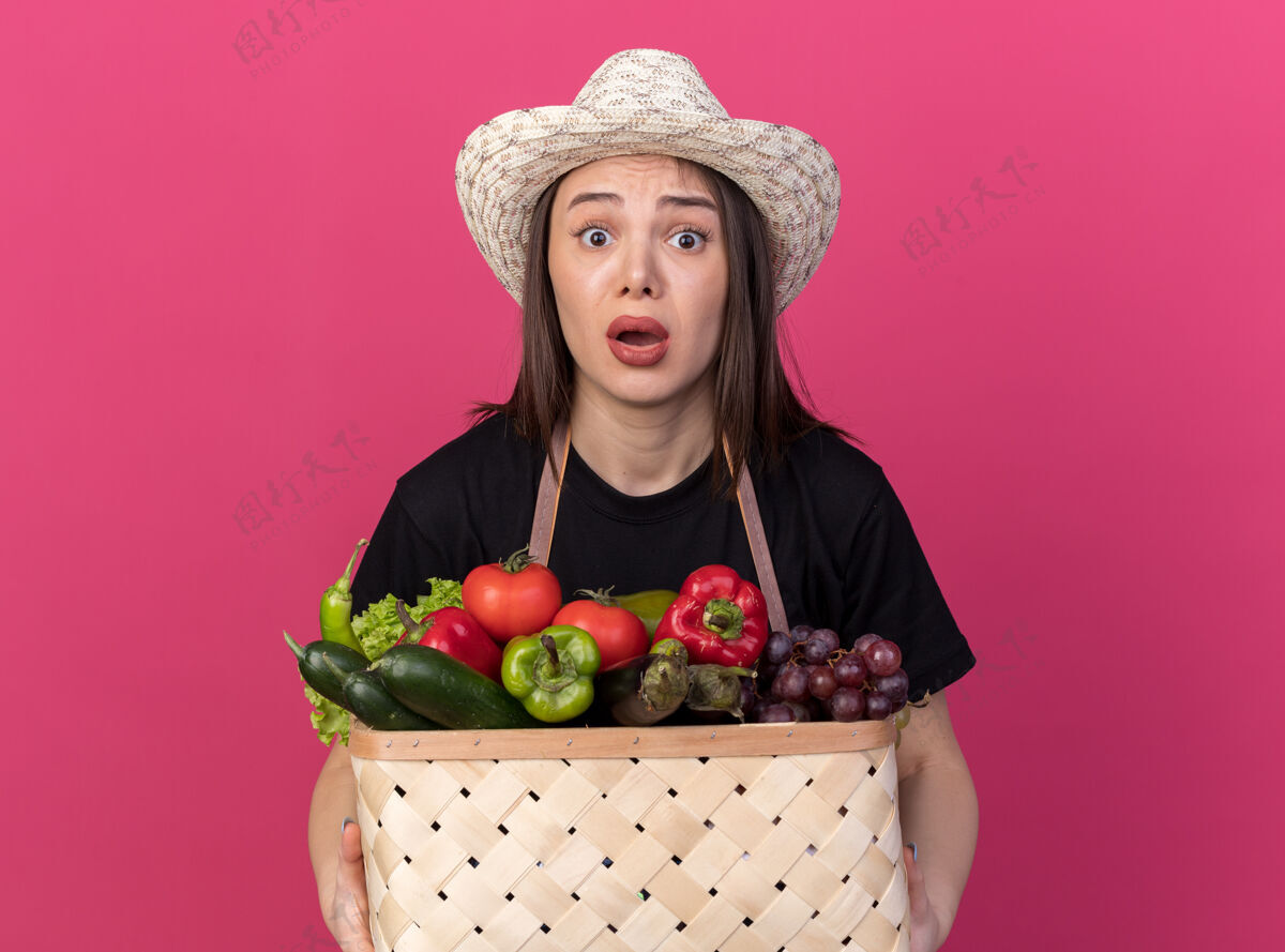 举行焦虑美丽的白人女园丁戴着园艺帽拿着菜篮子粉红色穿焦虑
