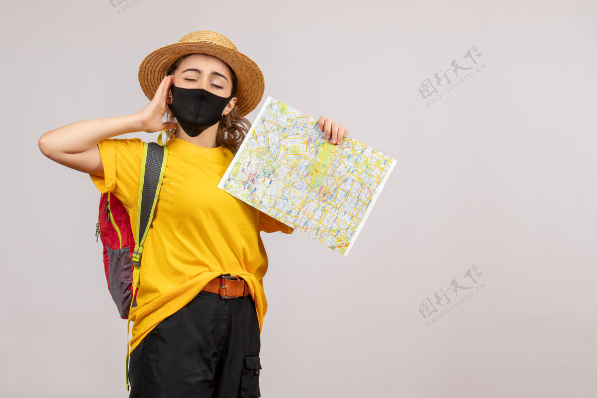 成人正面图背着背包的年轻女子举着地图闭上眼睛面具地图冒险