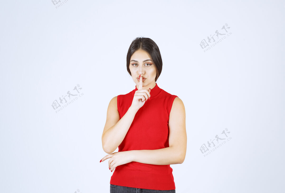 姿势穿红衬衫的女孩要求安静模特成年人年轻人