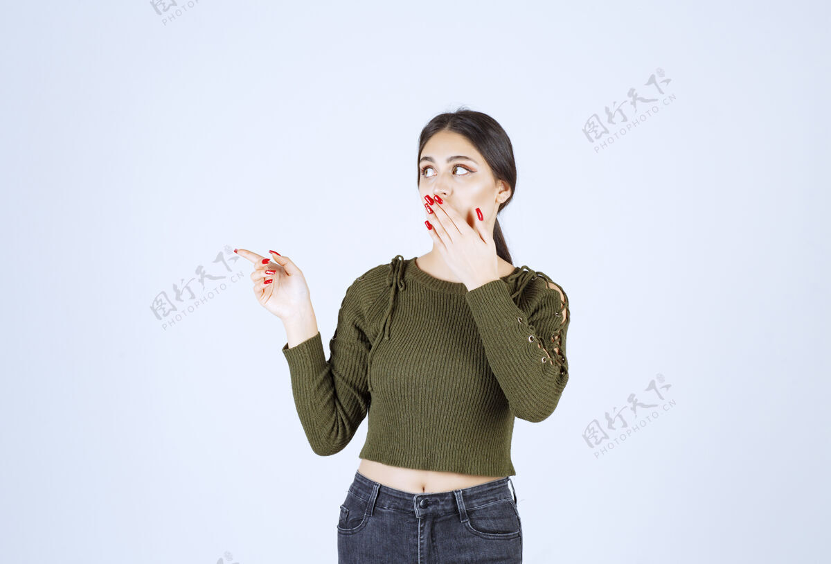 人年轻的女模特站在一边用食指指着人类手指女士