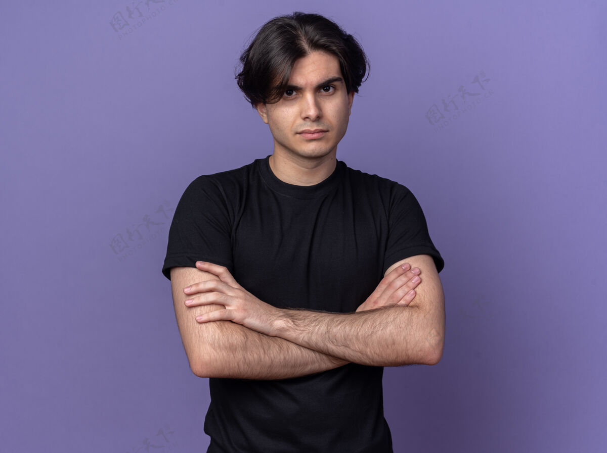 姿势自信的年轻帅哥穿着黑色t恤双手交叉隔离在紫色的墙上手男人公民