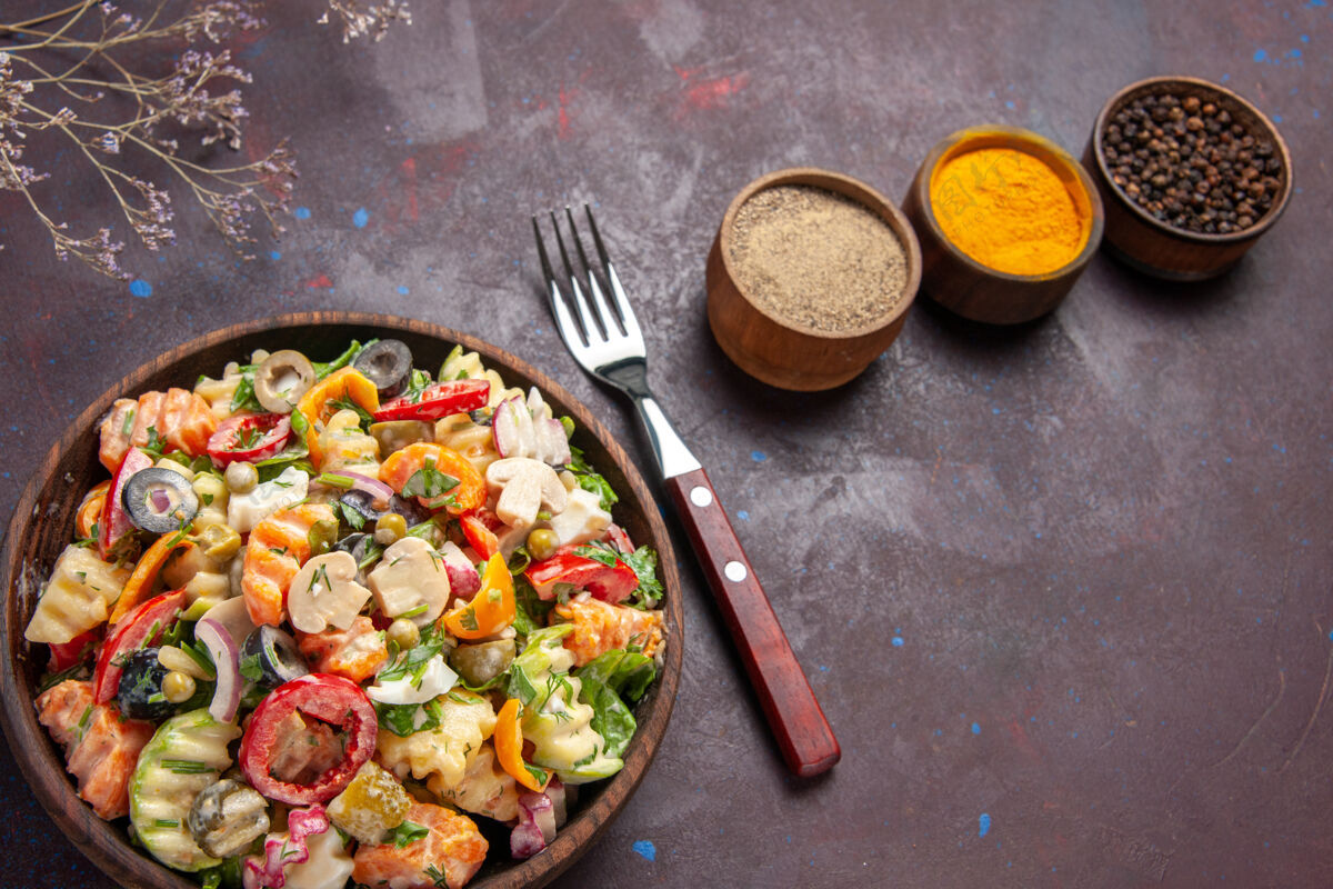 美味俯瞰美味的蔬菜沙拉与调味品在黑暗的背景健康饮食沙拉蔬菜午餐午餐饮食美味蔬菜沙拉