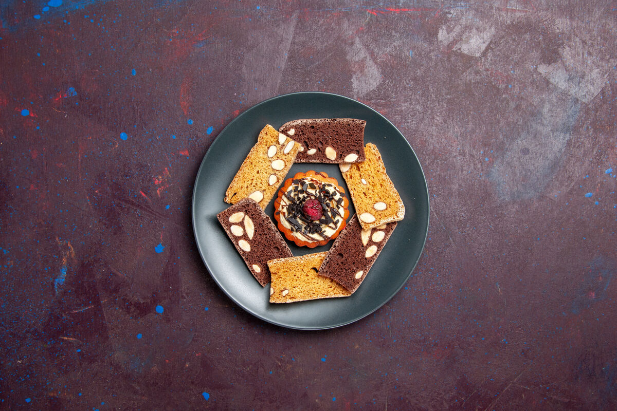 饼干俯瞰美味的蛋糕片与坚果和小饼干在黑暗的背景饼干饼干甜点蛋糕保护盖饼干碗