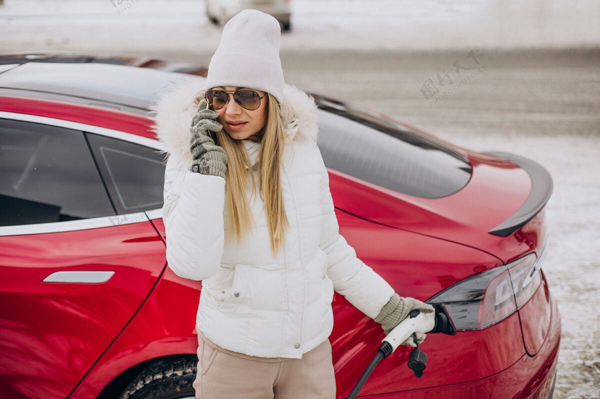 汽车女人充电红色电动车 在冬天的时候手机距离车辆