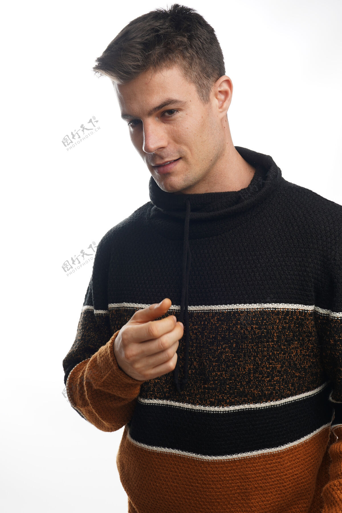 帅气特写肖像的年轻男子穿着温暖的条纹毛衣 并对白色的墙壁摆姿势温暖棉休闲