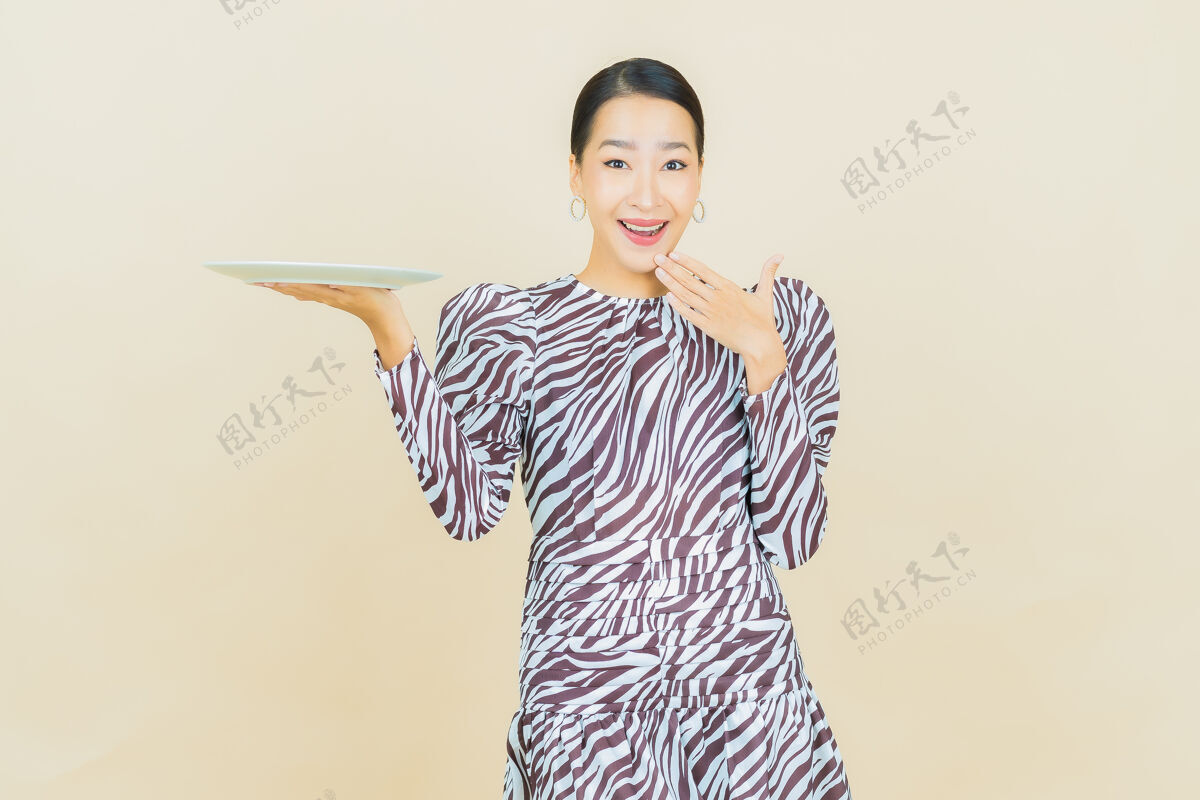 欢乐肖像美丽的亚洲年轻女子微笑着米色空盘子房子肖像围裙