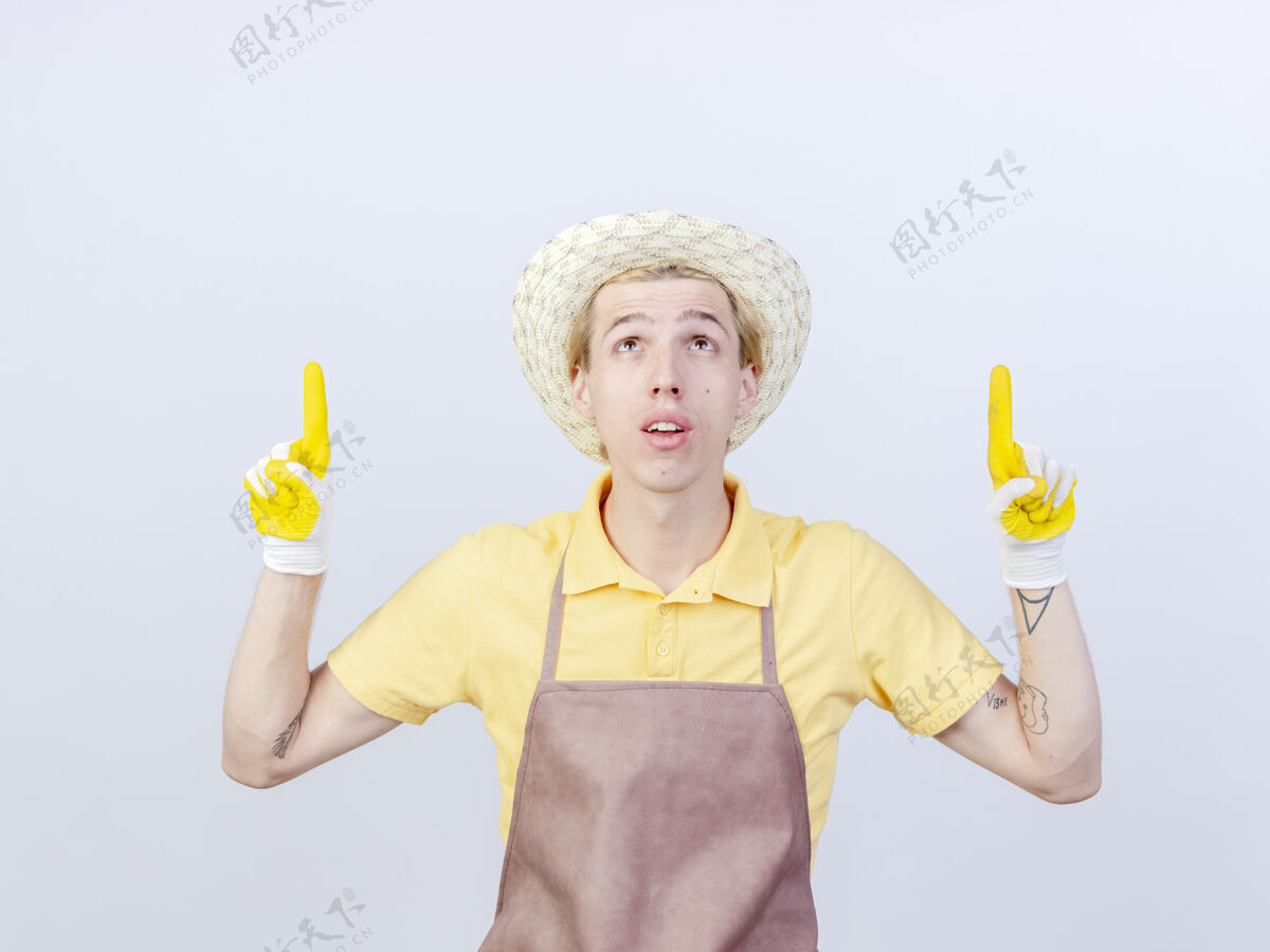 手指年轻的园丁 穿着连体衣 戴着橡胶手套 食指朝上连身衣指尖向上