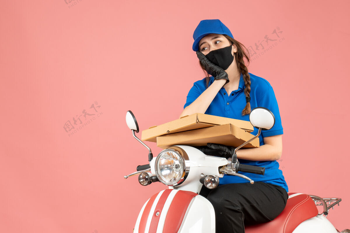 车辆俯视图：戴着医用口罩和手套的女快递员坐在滑板车上用粉彩桃子送订单思考面具男