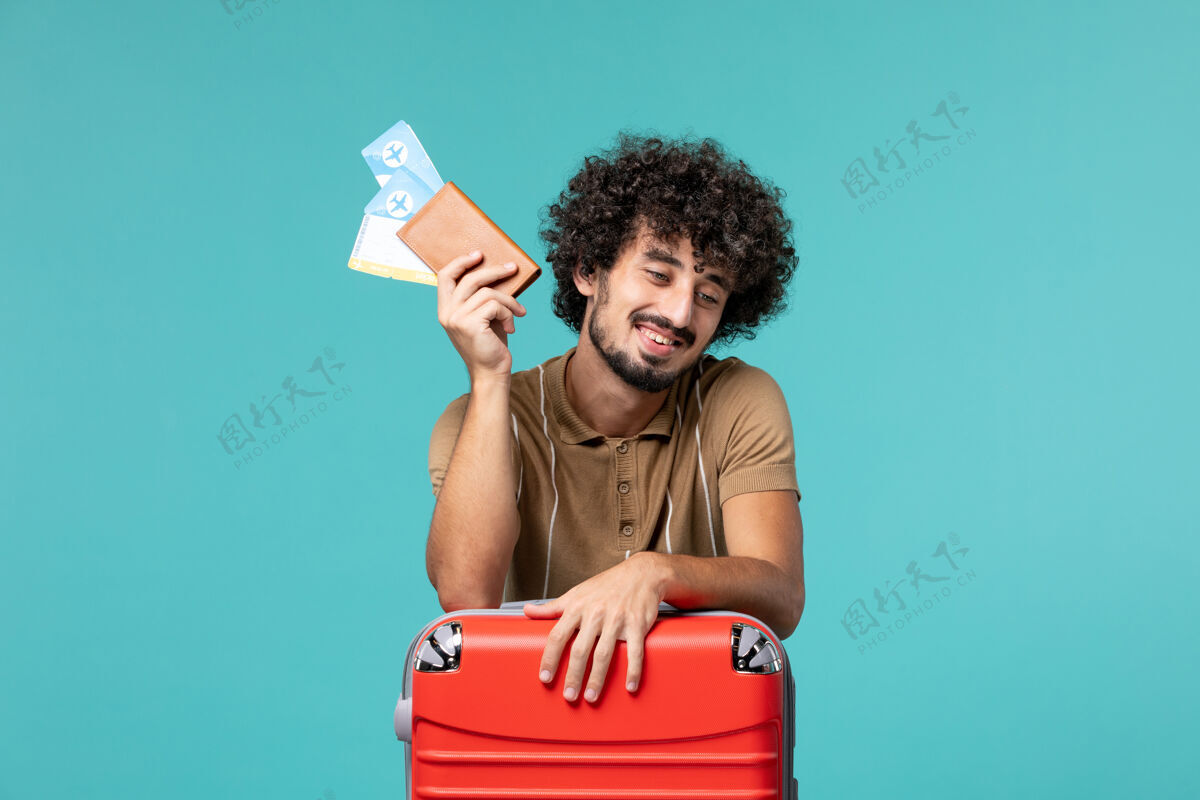 人度假的人拿着票 靠在蓝色的红袋子上航行假期票