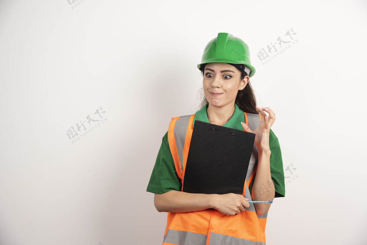 女人愤怒的女工程师与剪贴板上的白色背景高品质的照片安全帽工人人