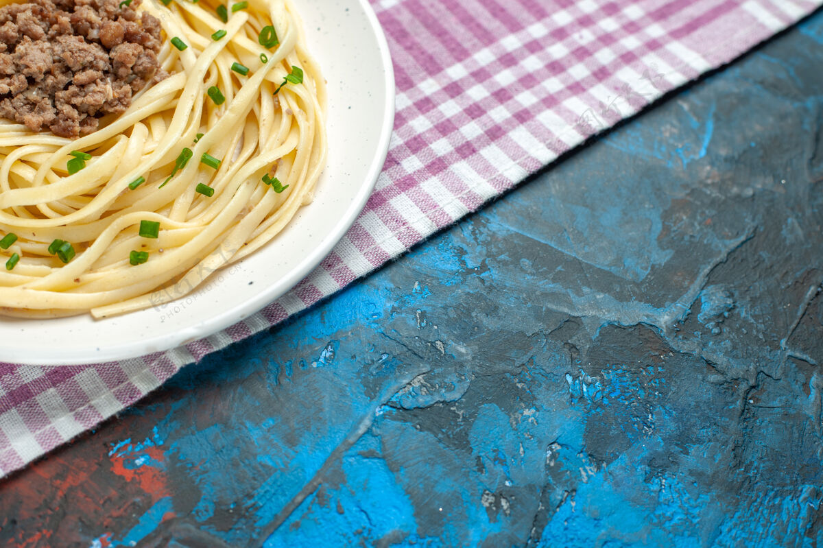 肉前视图美味的意大利面食与地面上的肉蓝色盘肉面团颜色的食物一餐菜肴前面