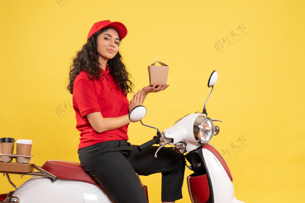 工作正面图女快递员骑自行车送咖啡和食物黄色背景服务工作服工作服女快递员成人摩托车工作