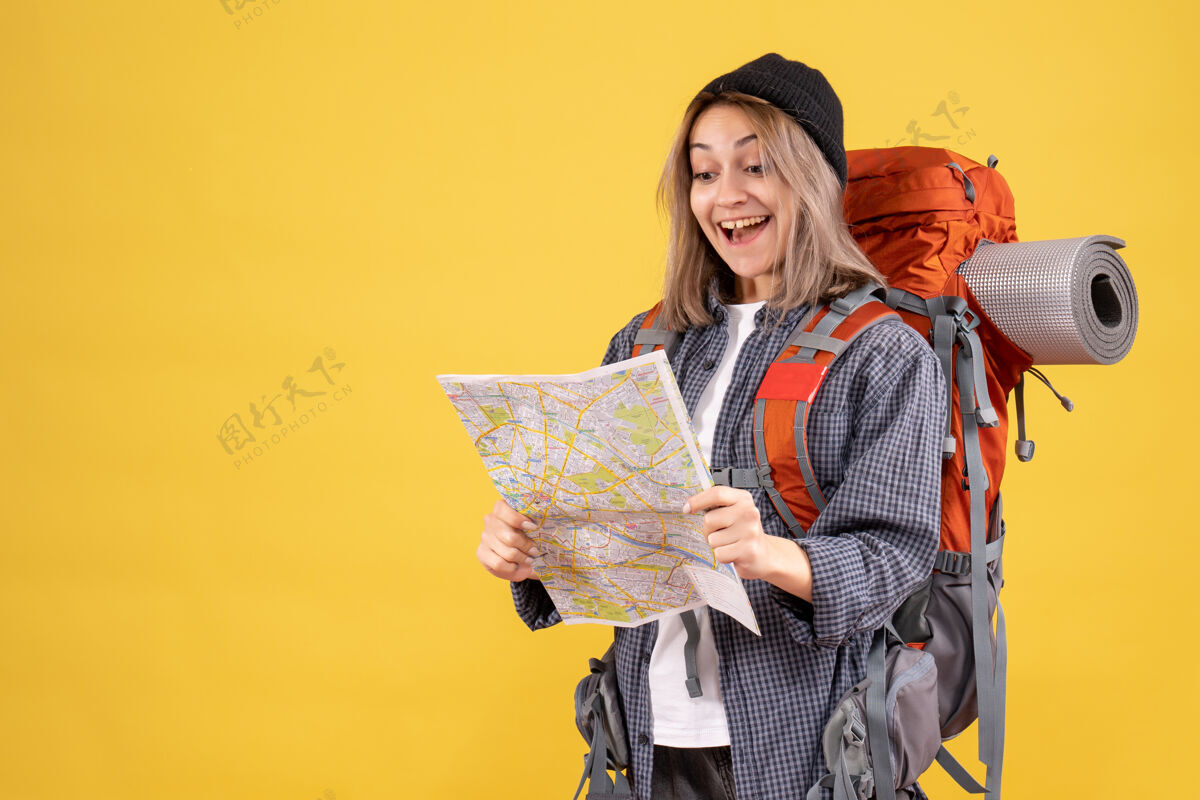 地图欣喜若狂的女旅行者背着背包看地图成人时尚背包