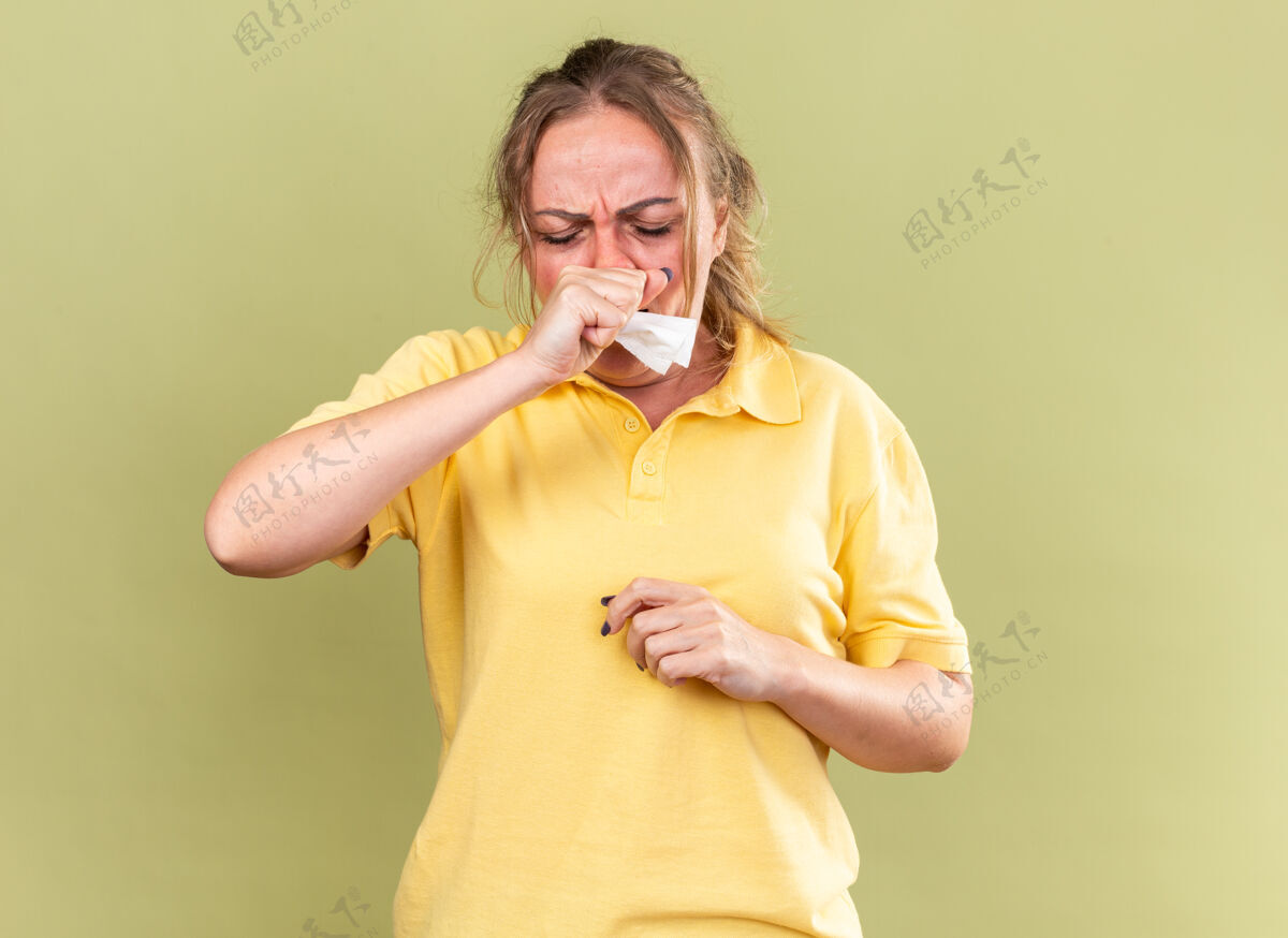 感觉一个穿着黄色衬衫的不健康的女人站在绿色的墙上 感觉很可怕 患流感和感冒 发烧 咳嗽流感不健康站立