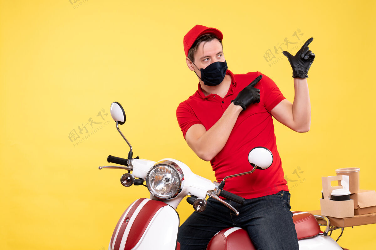 摩托车正面图：穿着红色制服 戴着黄色面具的男信使喜剧演员男信使人